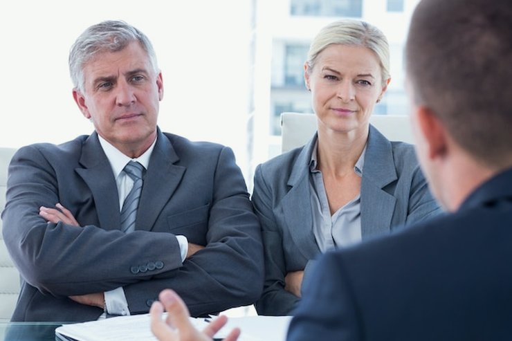 A client meeting with two advisers across a conference table
